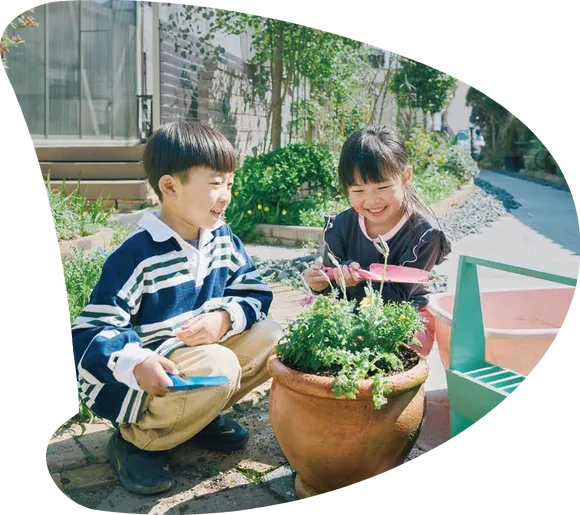植木鉢の草花を世話する男の子と女の子