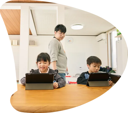 タブレットで学習する子どもたちとスタッフ